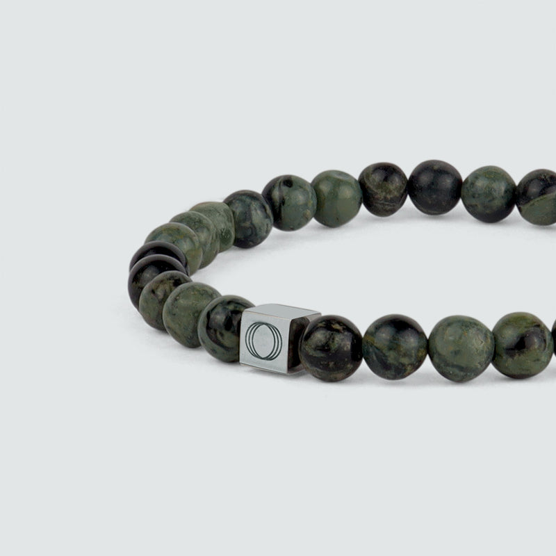 Close up angle of the Aghdar mens green beaded bracelet, showing the stone and the Ninetwofive logo detail.