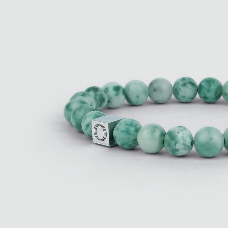 Zijaanzicht van de Akhdir-armband voor heren met jade-kralen, waarop de jade-kralen en het gegraveerde ‘Ninetwofive’-logo goed te zien zijn.