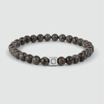 Een Albuna - Bruine Kralen Armband 6mm met een kraal van sneeuwvloksteen en een zilveren kraal.