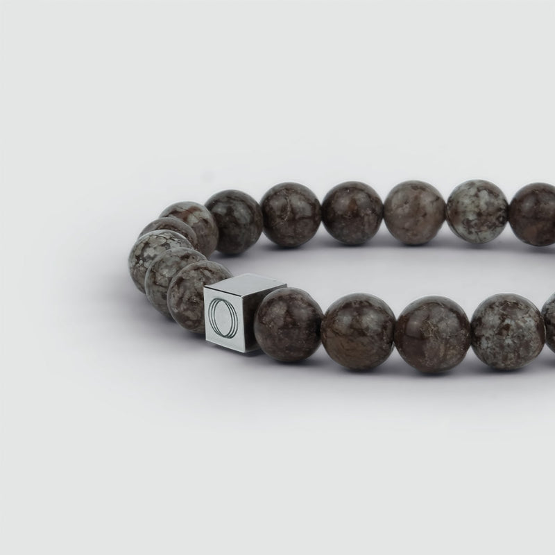 Close-up side angle of the Albuna brown mens bracelet, showing the beads and the visible Ninetwofive logo detail.