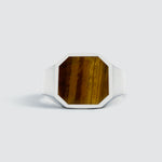 Une bague "Alem - Tiger Eye Stone Signet Ring 13mm" sur fond blanc.