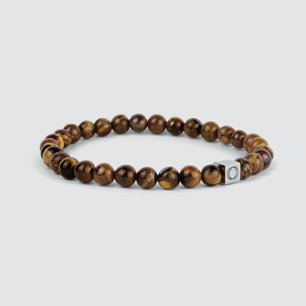 A Alnamr - Tiger Eye Beaded Bracelet 6mm with brown tiger eye beads and a silver clasp. The tiger eye stone beads have a beautiful weight and thickness that adds to their overall appeal.