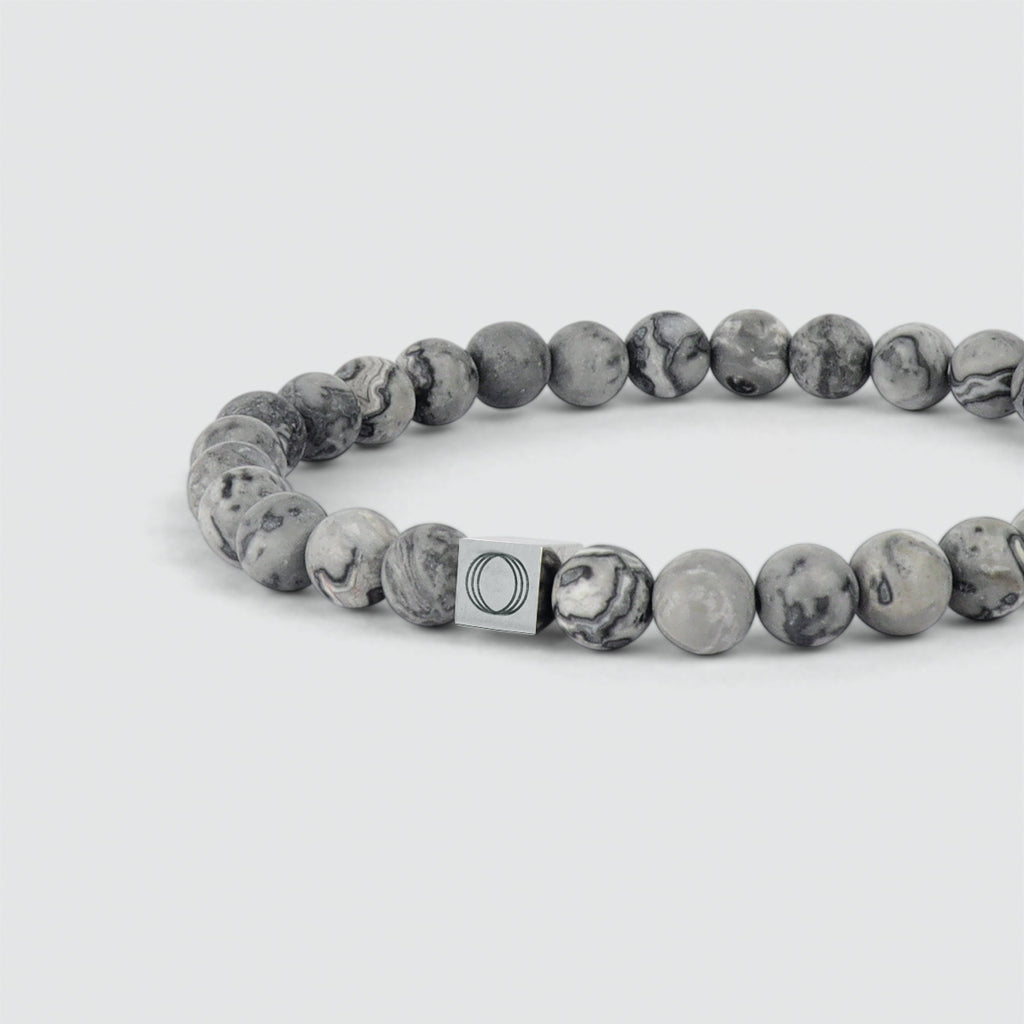 Un bracelet en perles grises de 6 mm avec un fermoir en argent.