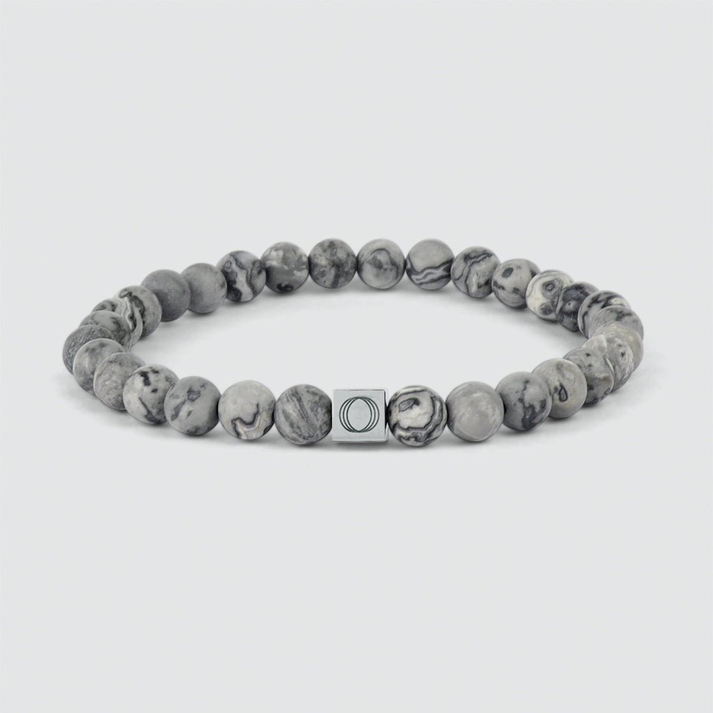 Bracelet en perles grises de 6 mm avec une perle en marbre gris et un fermoir en argent.