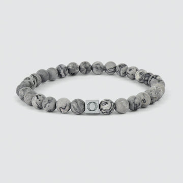 Bracelet en perles grises de 6 mm avec une perle en marbre gris et un fermoir en argent.
