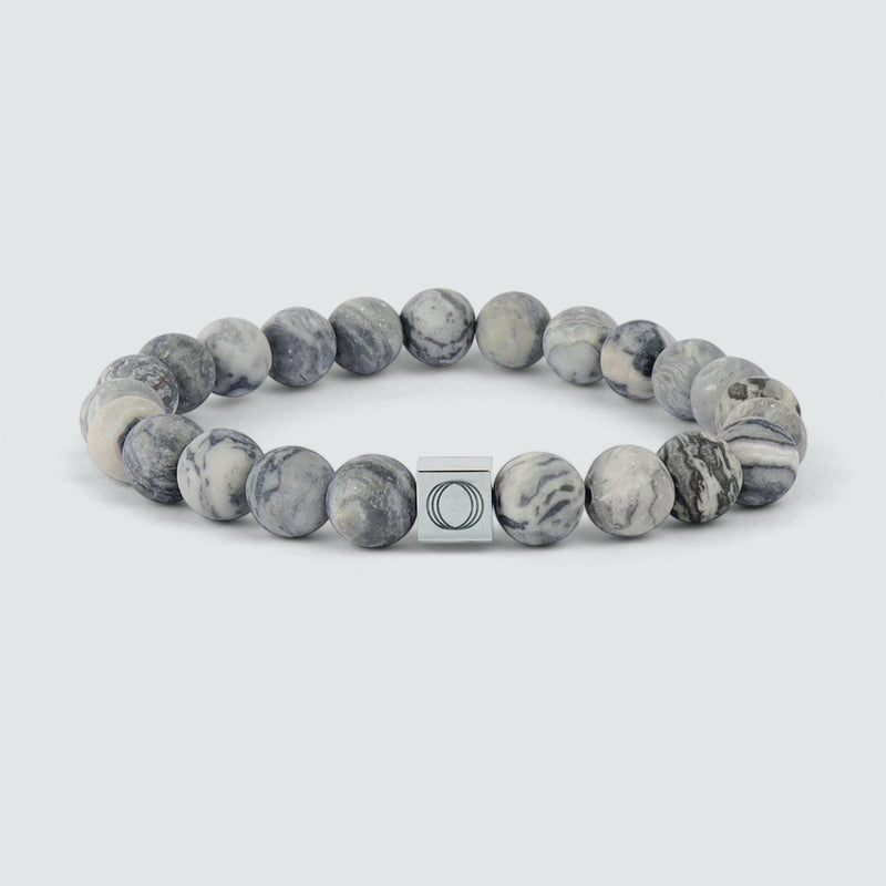Vooraanzicht van de grijze kralenarmband van Alrazas, met een marmeren kraal en het logo ‘Ninetwofive’ erin gegraveerd.