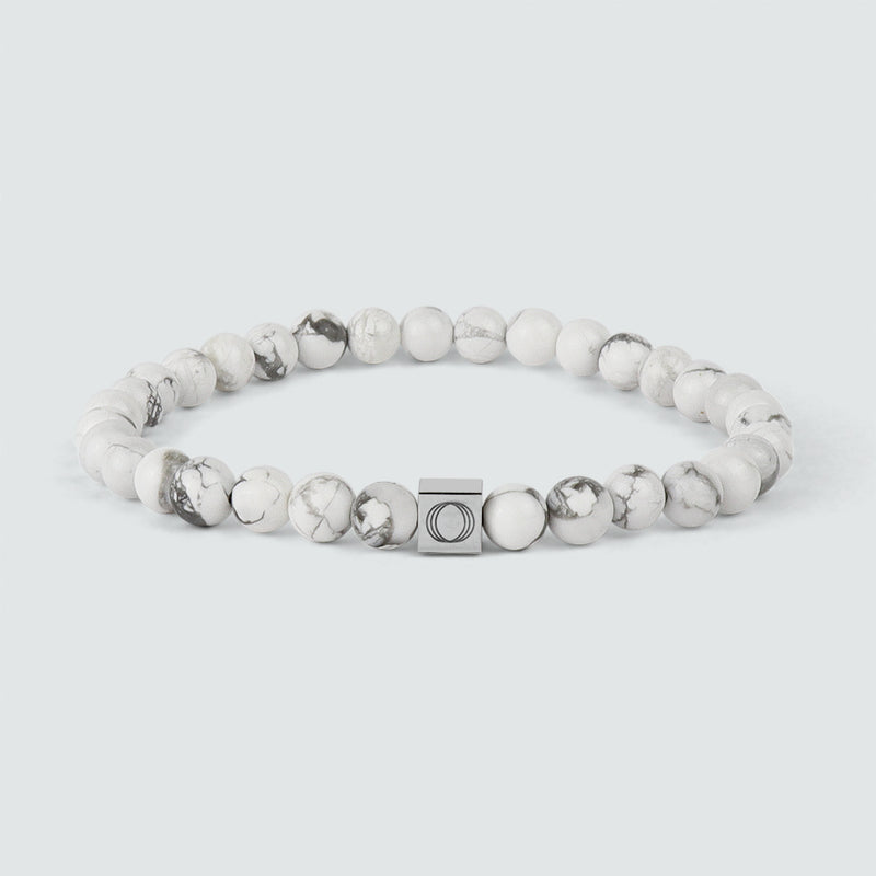An Alrukham white beaded bracelet with detailed look of beads and engraved Ninetwofive logo.