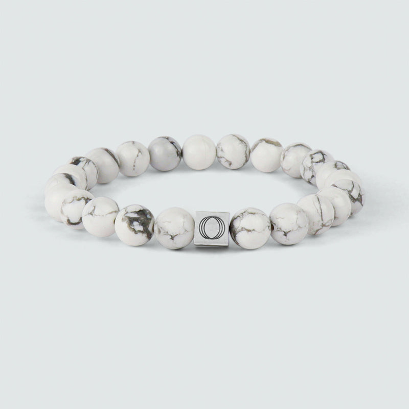 Vooraanzicht van de Alrukham-armband voor heren met kralen, met een gedetailleerde weergave van wit marmer en het gegraveerde logo van Ninetwofive.