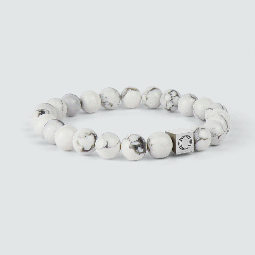 Alrukham - White Beaded Bracelet 8mm avec une perle de marbre noir et blanc, présentant un effet de pierre altérée.