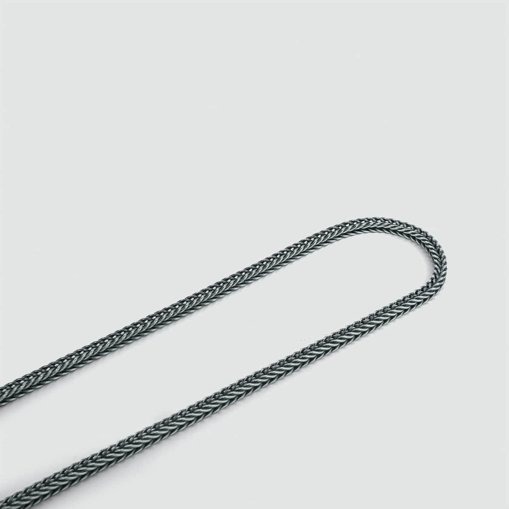 A handmade Anis - Sterling Silver Wheat Chain Necklace 3mm with a knot on it, crafted with 925 silver, on a white surface.