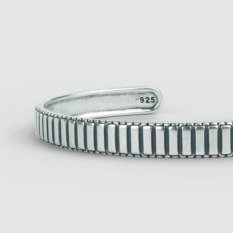 Ein Kenan-Herren-Armreif aus Sterlingsilber, 7 mm, mit schwarz-weißem Streifen – perfekt für den stilbewussten Mann.