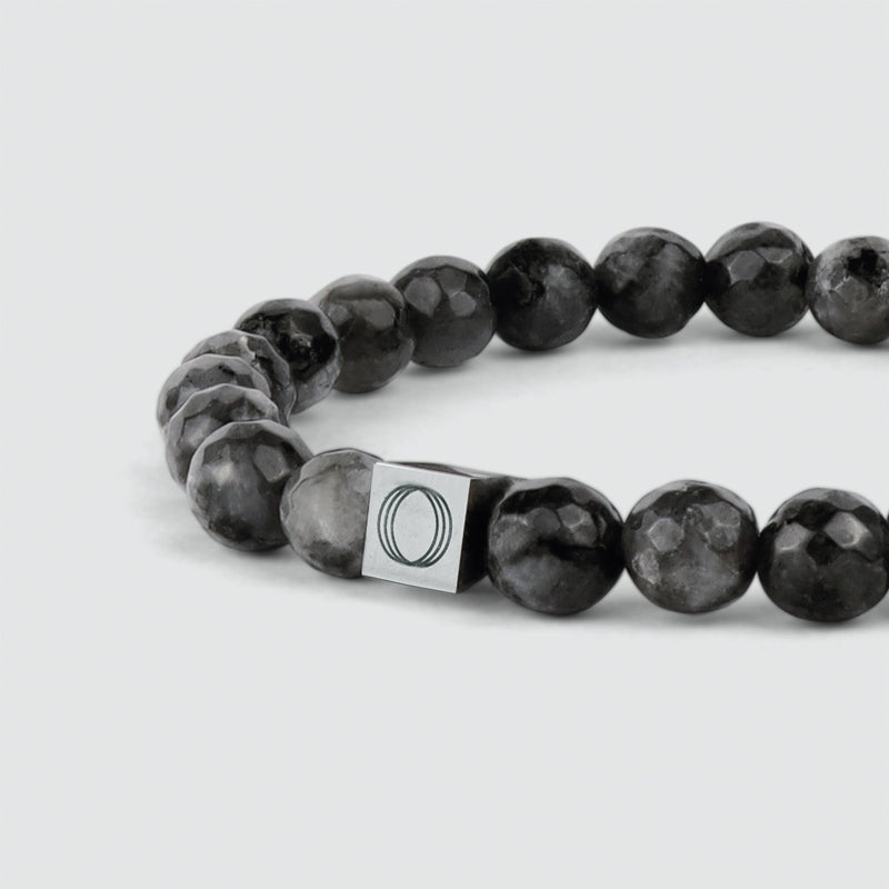 Close up side angle of the Aswad mens black beaded bracelet, showing the Ninetwofive logo detail.