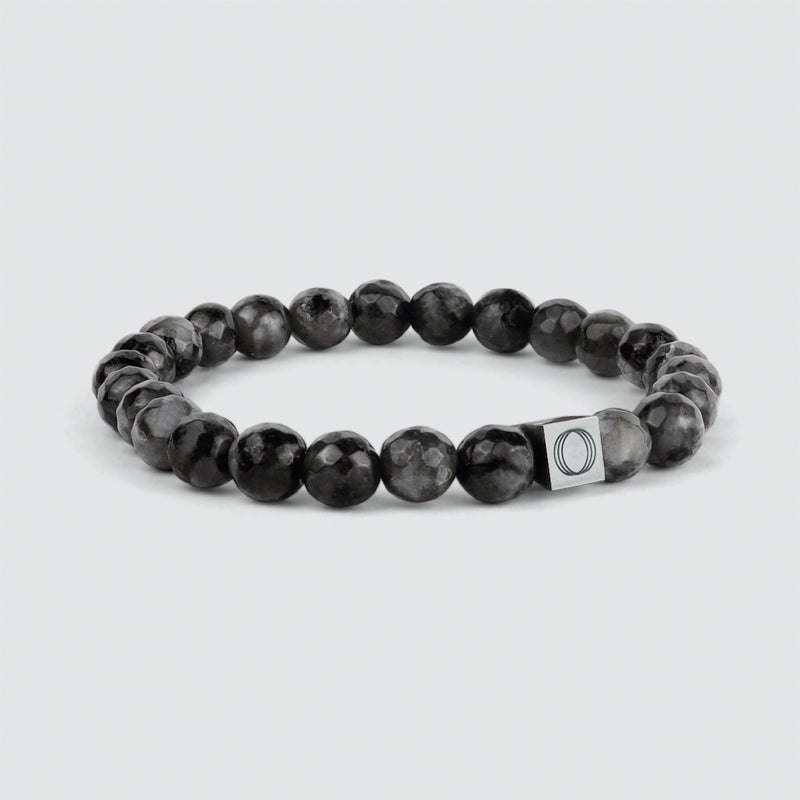 Side view of the Aswad black beaded mens bracelet, featuring a spectrolite stone, showcasing engraved Ninetwofive logo.