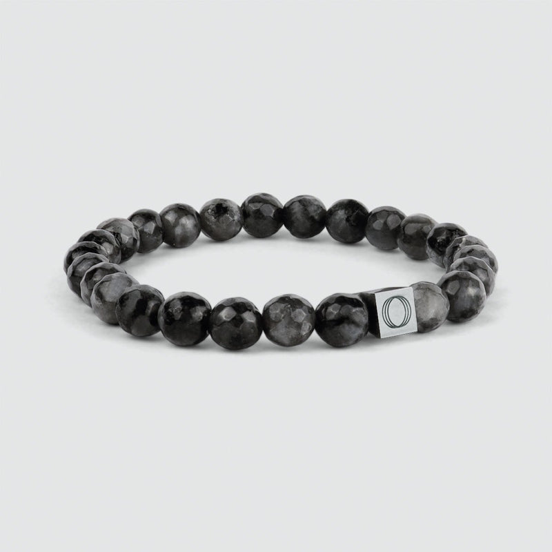 Angle view of the Aswad black beaded mens bracelet, featuring a spectrolite stone, showcasing Ninetwofive logo.