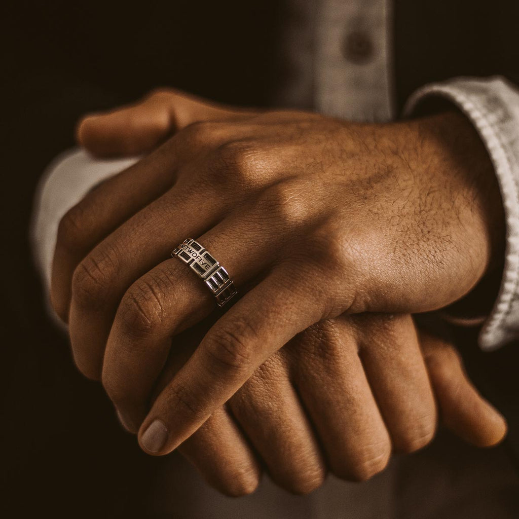 Die Hände eines Mannes präsentieren einen Ayman - Oxidierter Sterling Silber Ring 7mm für ihn.