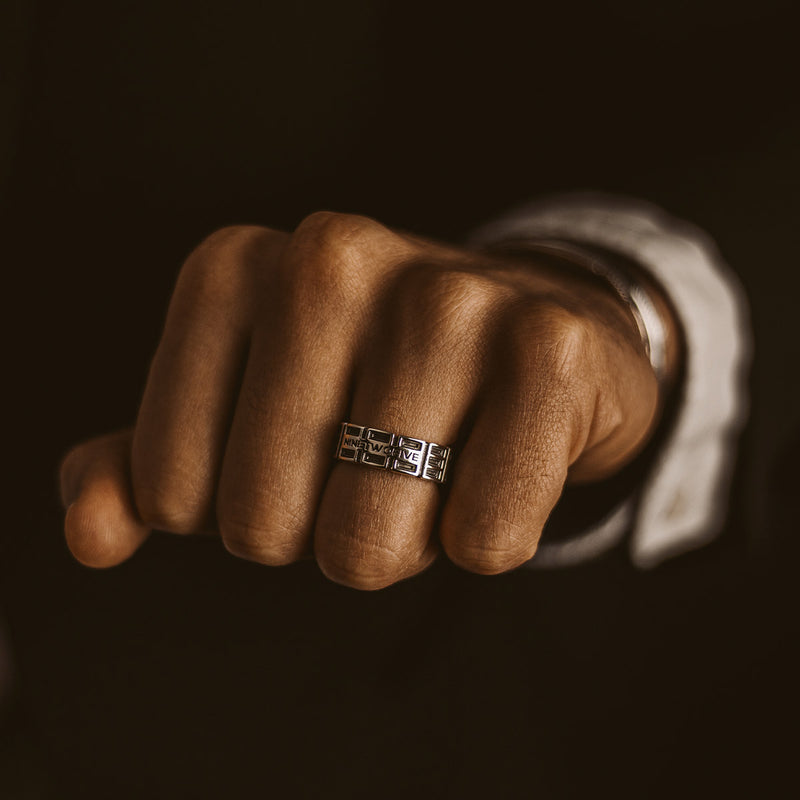 Ein Mann präsentiert den Ayman oxidierten Sterling Silber Herrenring von Ninetwofive.