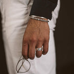 Ein Mann trägt den Rayen - Silver Cuban Link Ring 9mm und eine Brille.