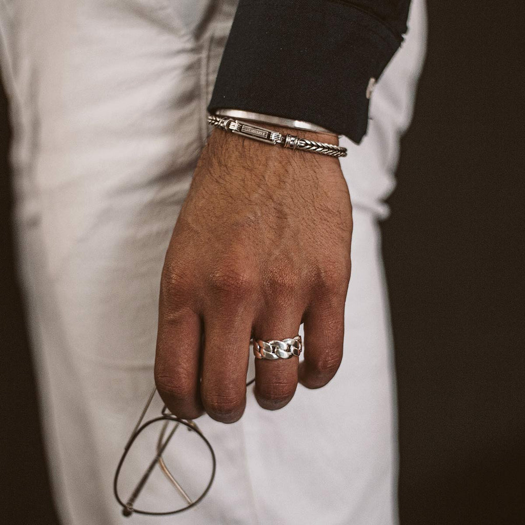 A man wearing the Rayen - Silver Cuban Link Ring 9mm and a pair of glasses.