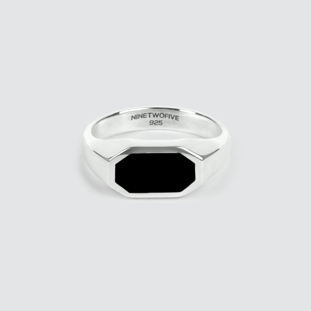 Ein Aniq - Eleganter schwarzer Onyx Siegelring 7mm für Männer, set vor einem sauberen weißen Hintergrund.