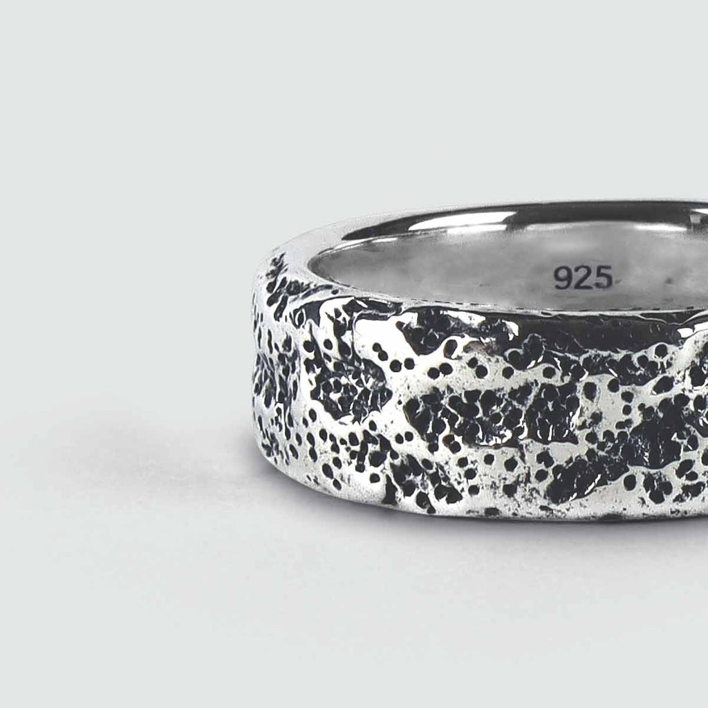 A close up of a silver ring designed for men