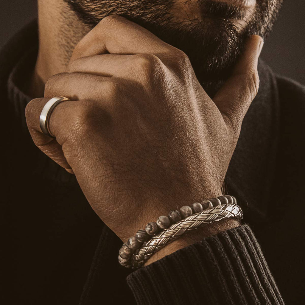 Ein bärtiger Mann trägt eine Idris - Braided Silver Armreif 8mm und einen Ring.