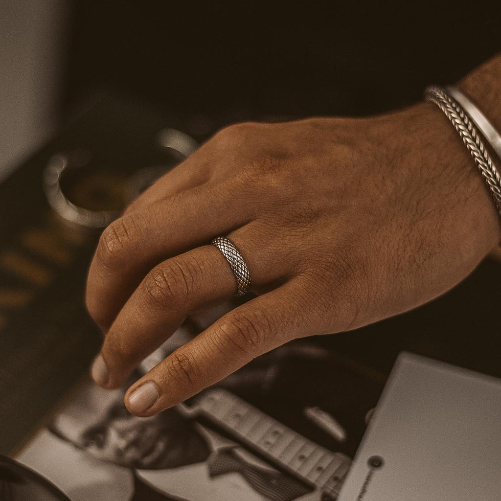 Een mannenhand met de Ferran - Geoxideerde Sterling Zilveren Ring 6mm eraan.