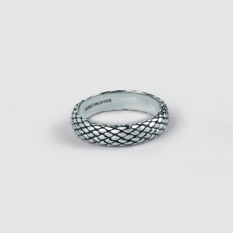 Man's hand wears the Ferran oxidised silver ring on his ring finger, layered with a silver bracelet and cuff from Ninetwofive.