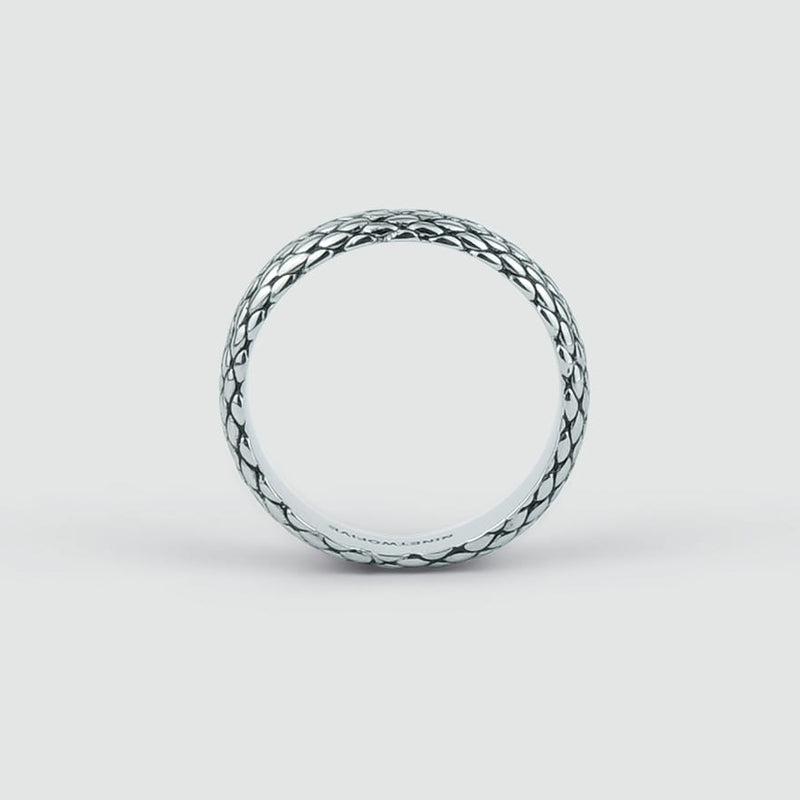 Ferran oxidised sterling silver mens ring with a braided pattern standing vertically on a contrasting white background.