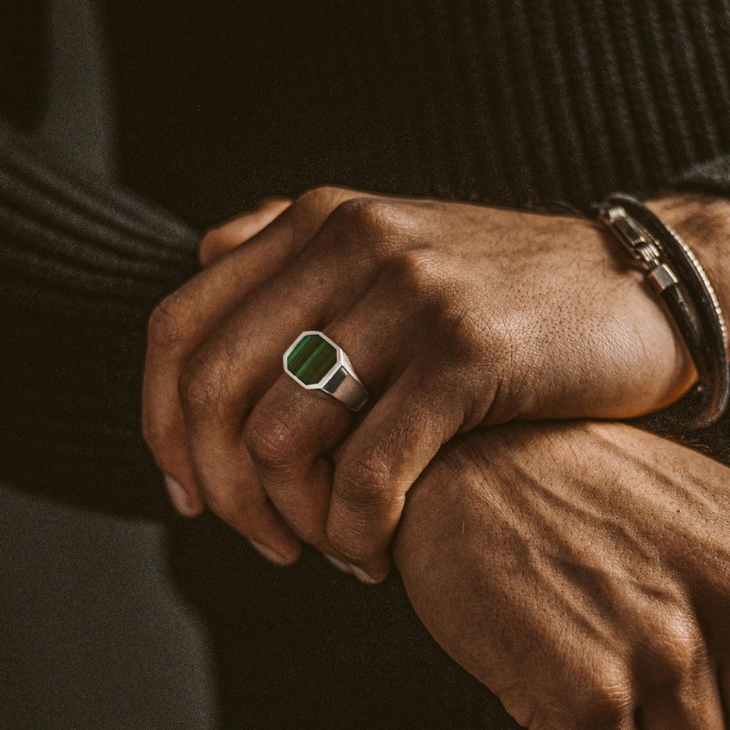 Een man draagt een Zaid - Sterling Zilveren Malachiet Zegel Ring 13mm met een smaragdgroene steen.