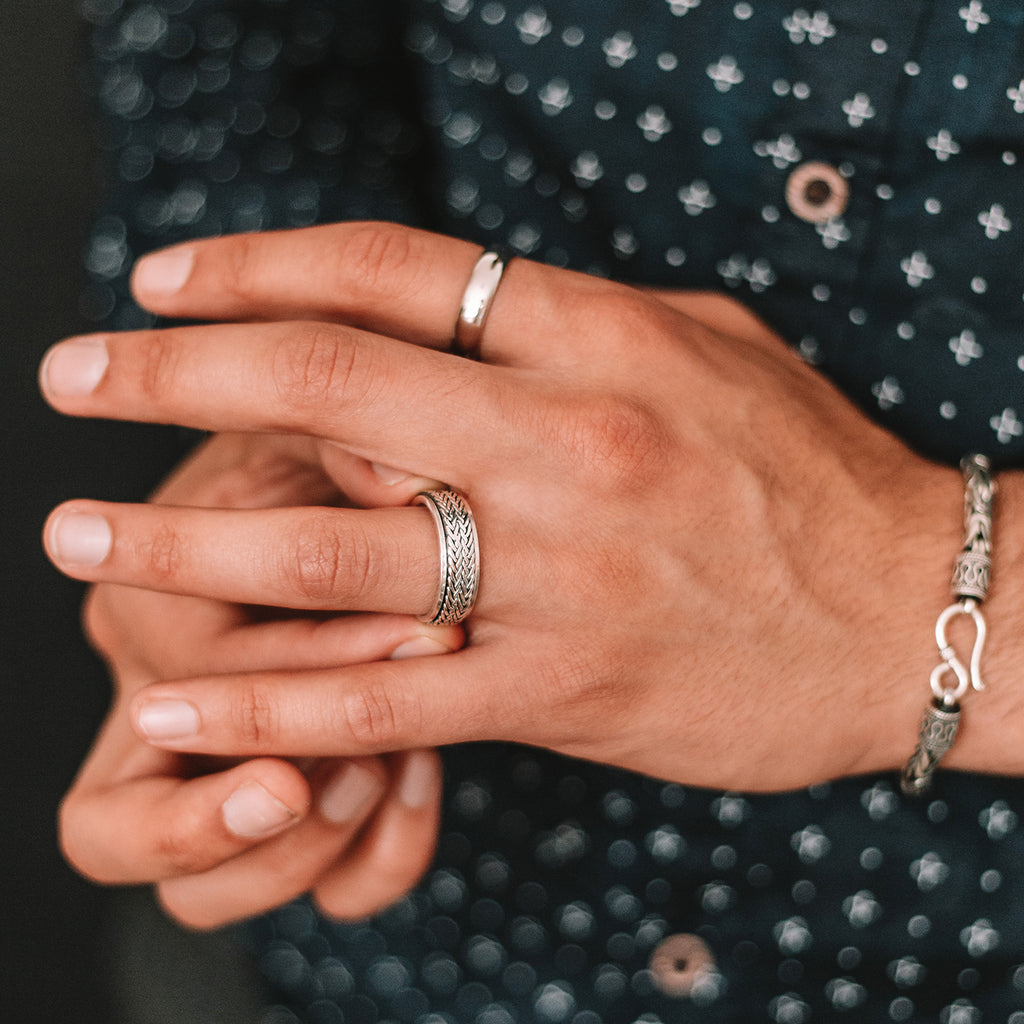 Die Hand eines Mannes mit einem Hani - Sterling Silber Spinner Ring 8mm fein graviert geschmückt.