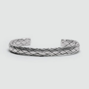 A solid silver Idris - Braided Silver Bangle Bracelet 8mm with a braided design.
