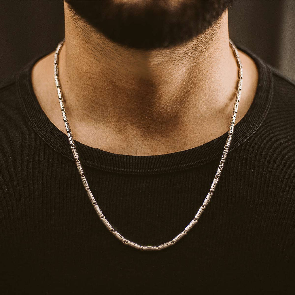 A man with a beard wearing a Kadeem - Sterling Silver Ornaments Chain Necklace 3.5mm.