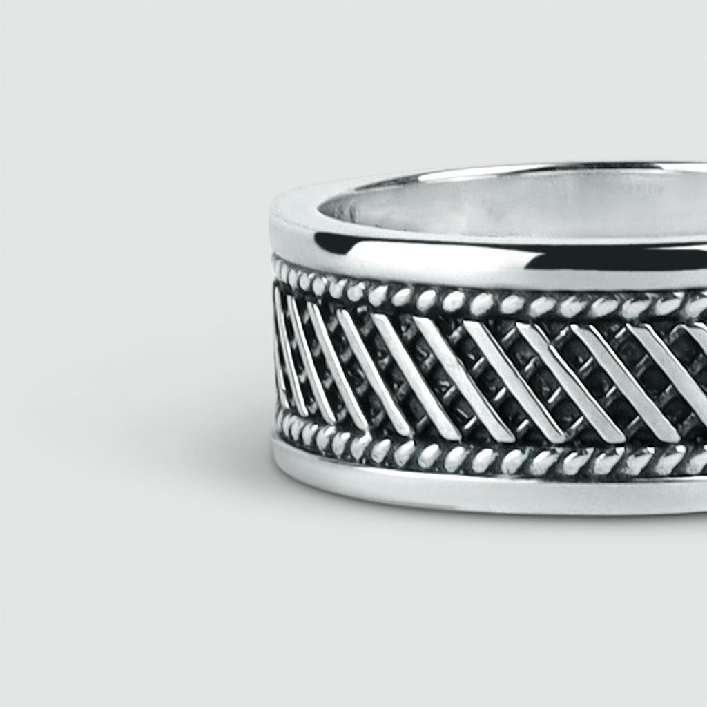 A Kaliq - Oxidized Sterling Silver Ring 10mm with a braided design.