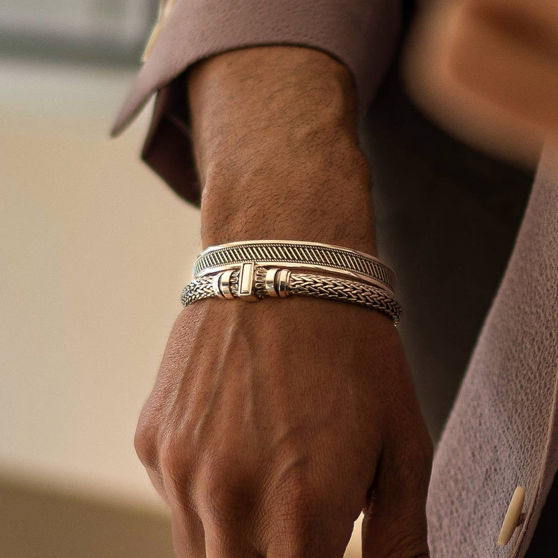 A man in a suit is wearing a NineTwoFive's Mirza sterling silver mens bracelet and a cuff bangle.