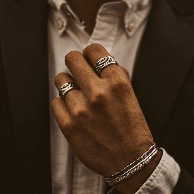 A man in a suit is wearing a Kaliq oxidized sterling silver mens ring and other Ninetwofive jewellery.