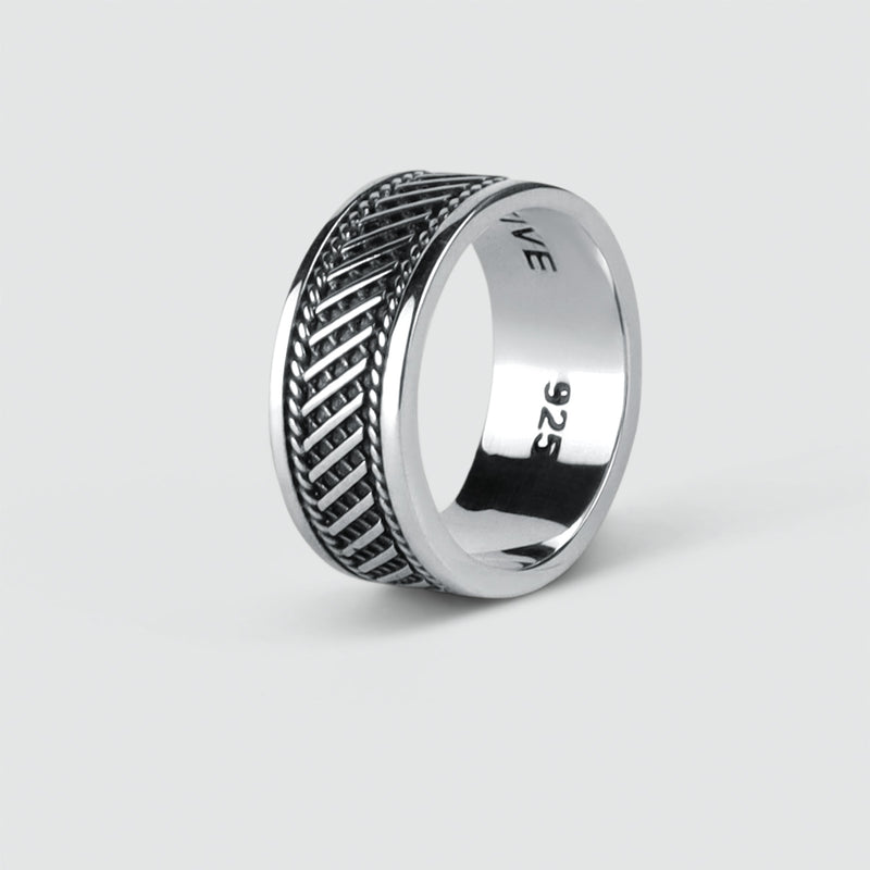 A mens Kaliq oxidized sterling silver mens ring with an engraved herringbone pattern.