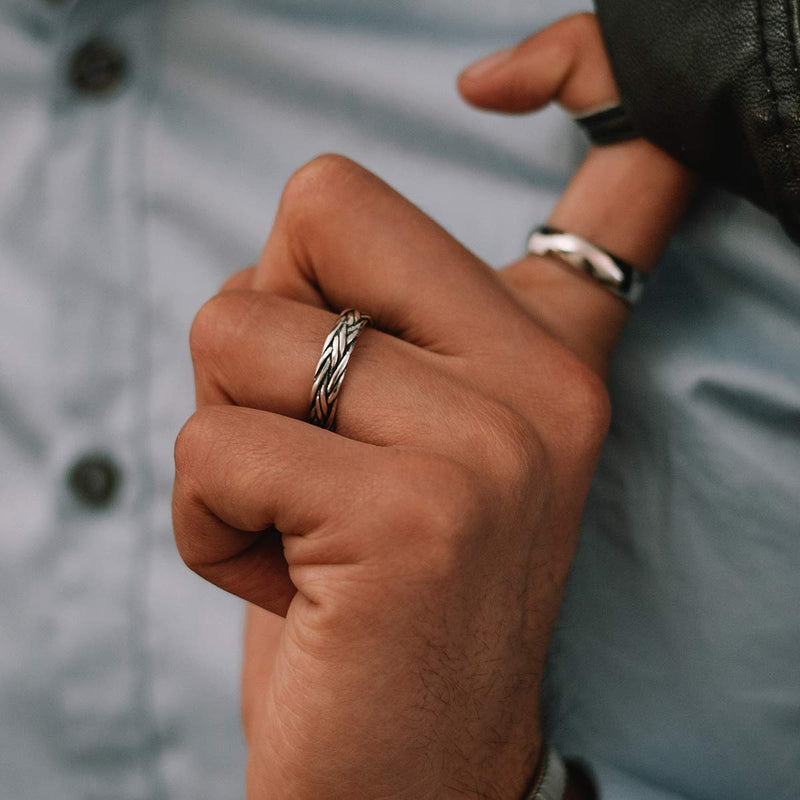 Model in a blue shirt wears the Ninetwofive Latif 5mm thin sterling silver braided mens ring on his ring finger.