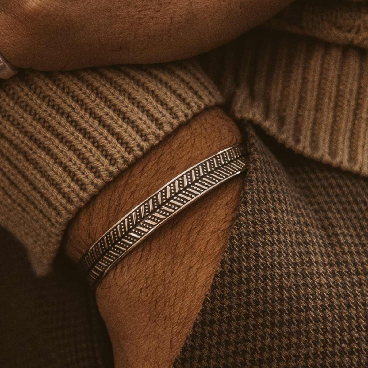 Un homme portant un bracelet Danyal - argent sterling oxydé Jonc 9mm avec un motif.
