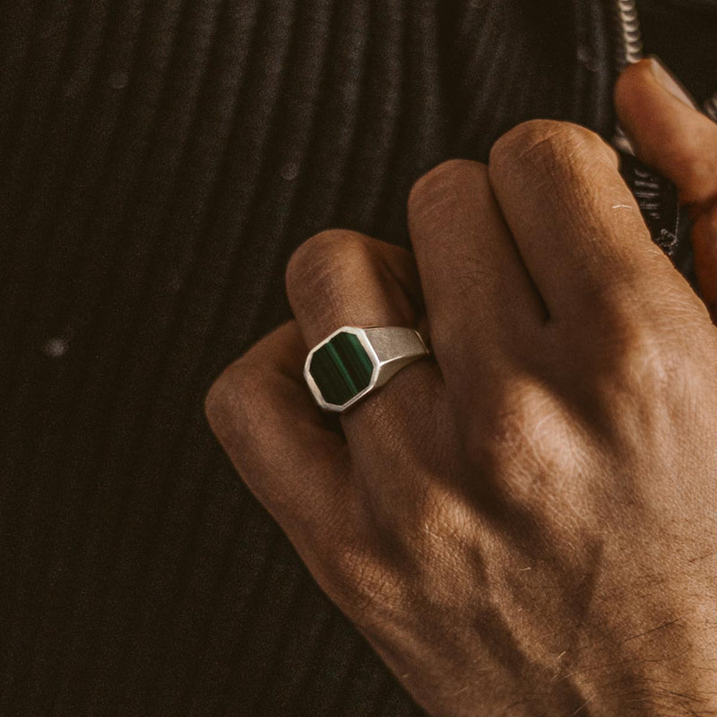 Een man draagt de Zaid 925 sterling zilveren zegelring voor heren met een groene steen aan zijn ringvinger.
