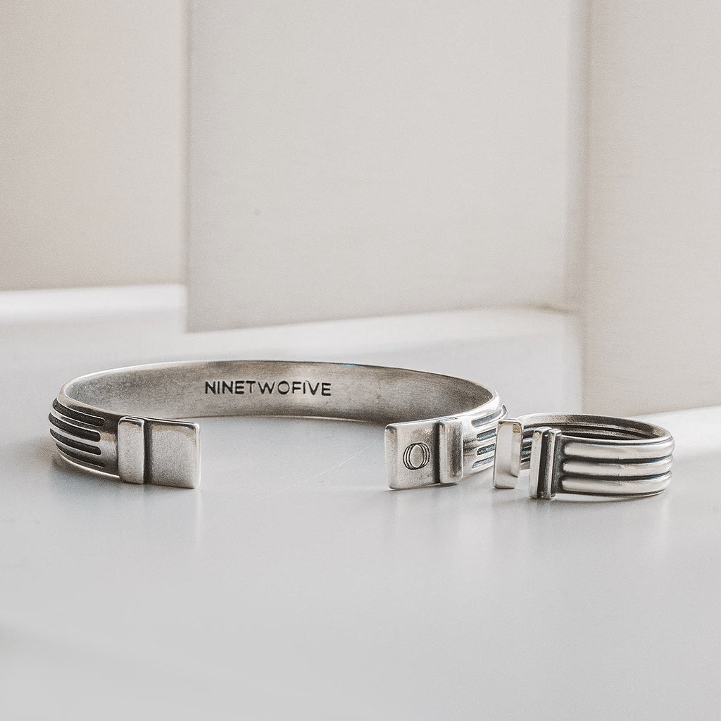 A set of Arkan and Mateen - 925 Silver cuff bracelets is placed on a table.