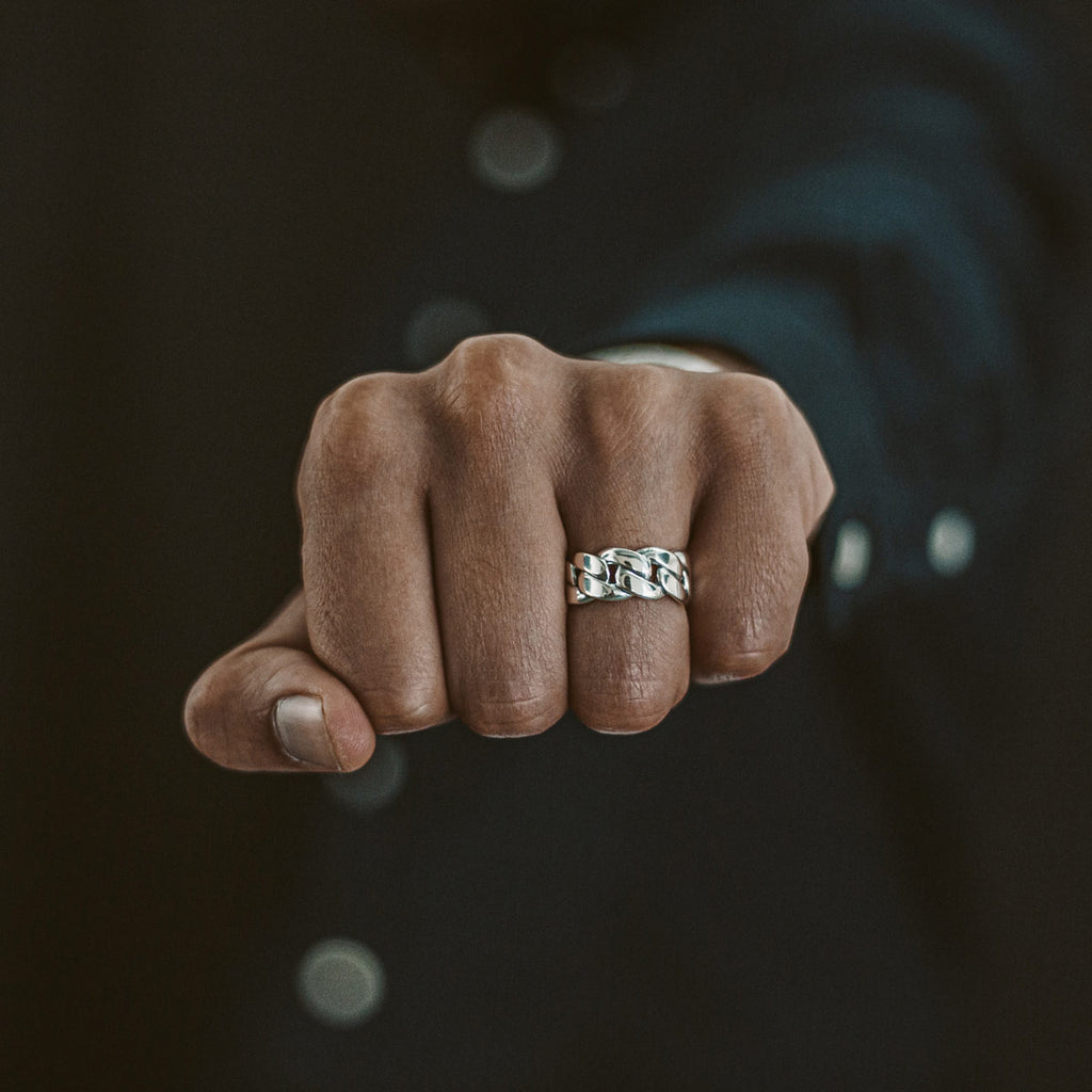 The Rayen - Silver Cuban Link Ring 9mm adorns a man's fist.