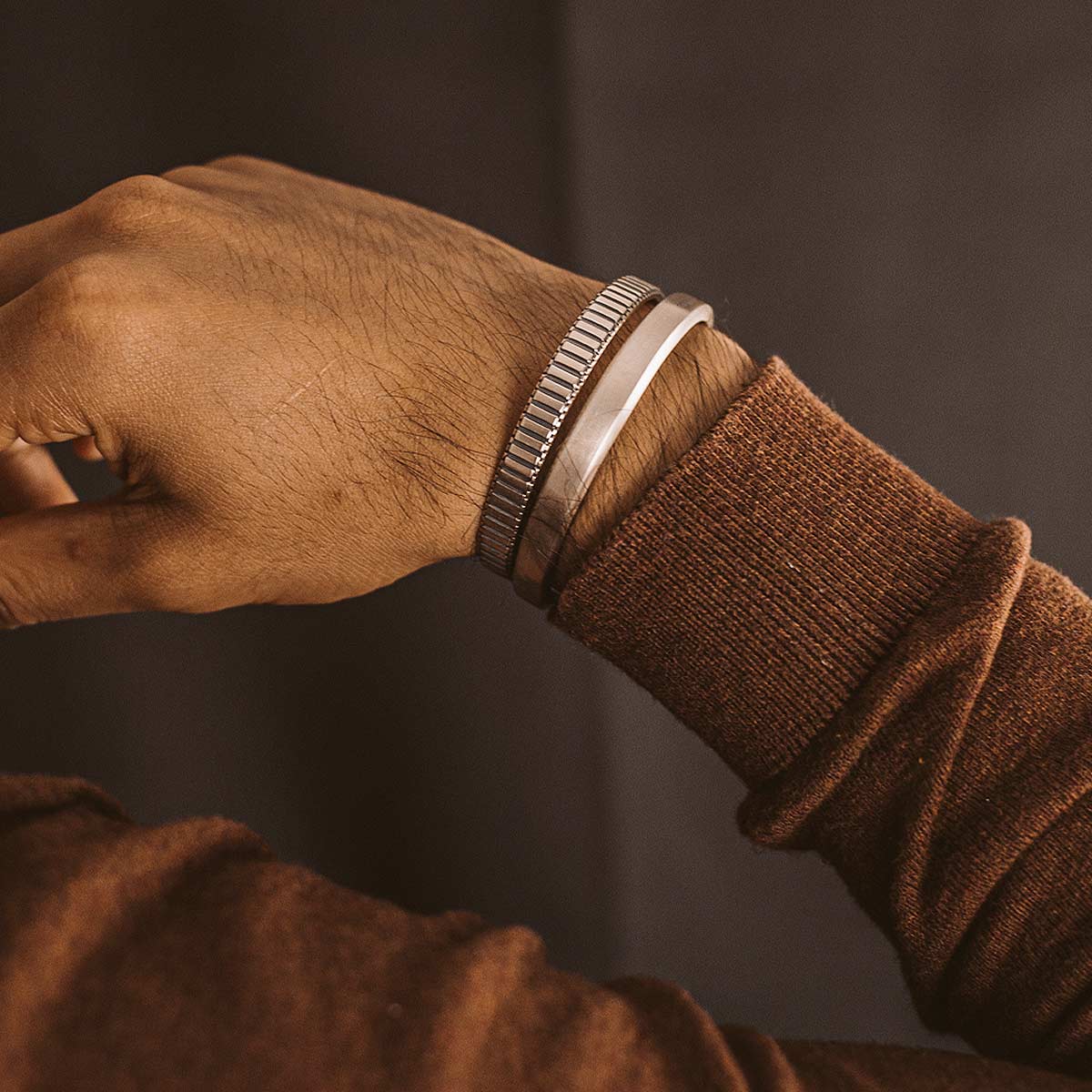 Un homme portant un pull marron et une manchette Boulos - Plain Sterling Silver Jonc Bracelet 8mm.