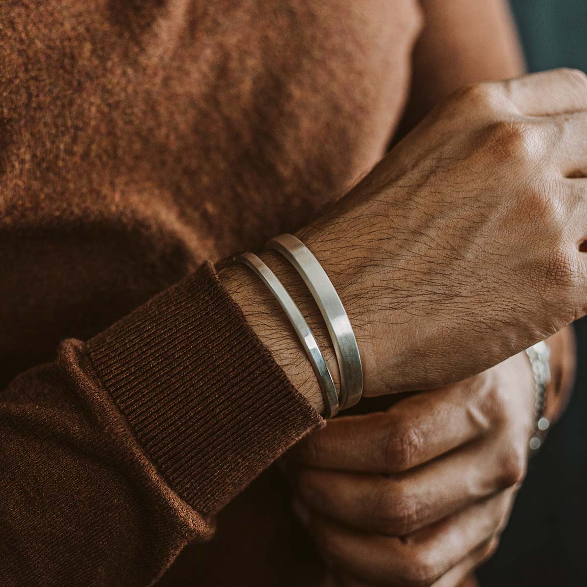 Ein Mann trägt ein Manschettenarmband von Boulos und Noor - set .