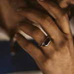 A man wearing an Aniq - Elegant Black Onyx Signet Ring 7mm on his hand.