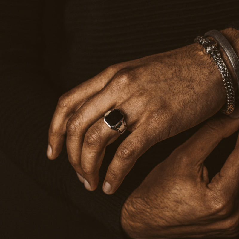 Model met de Baki zwarte onyx zegelring en een stijlvolle heren armband, beide van Ninetwofive.