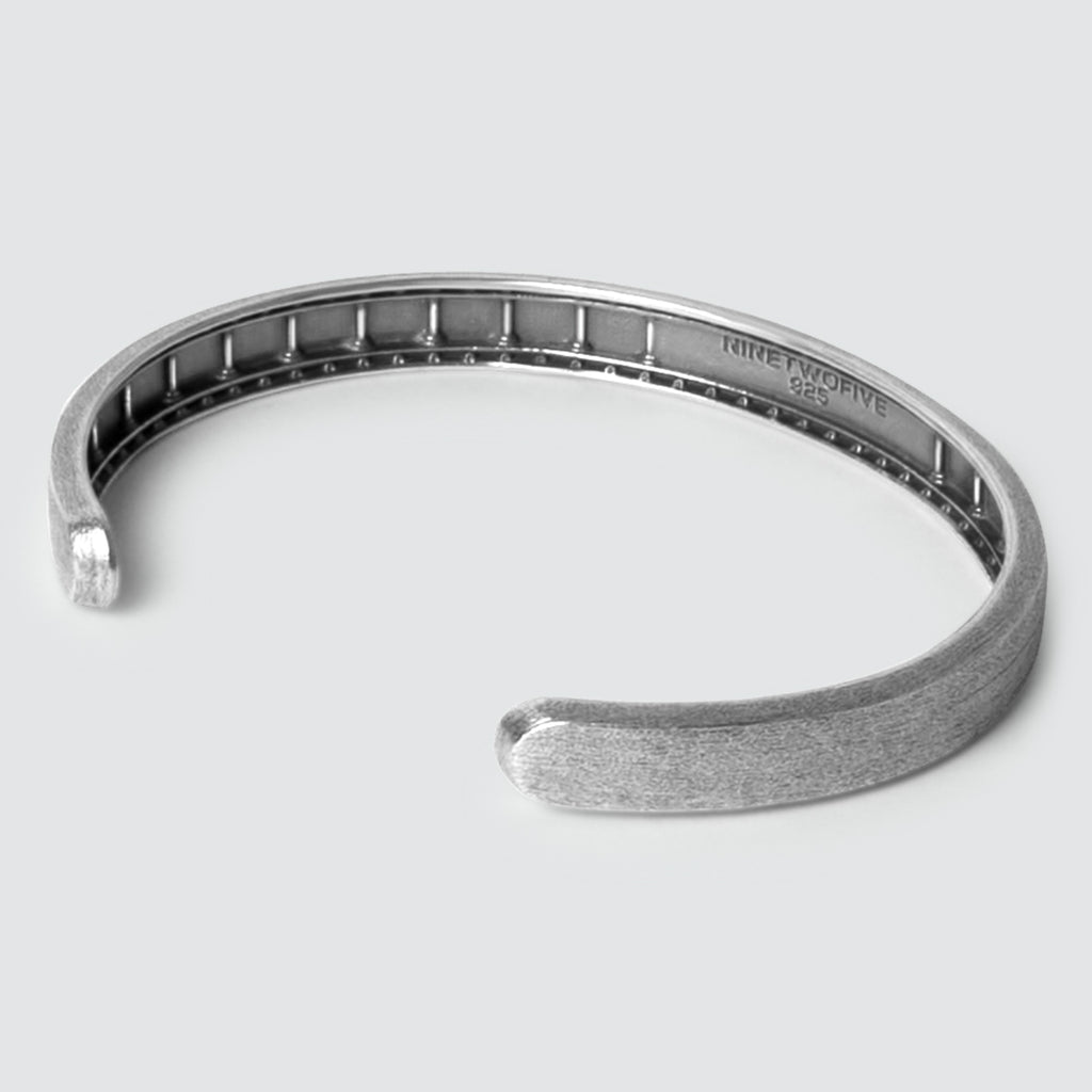 Ein Fudail - Rough Brushed Sterling Silber Armreif 8mm für Männer, präsentiert vor einem weißen Hintergrund.