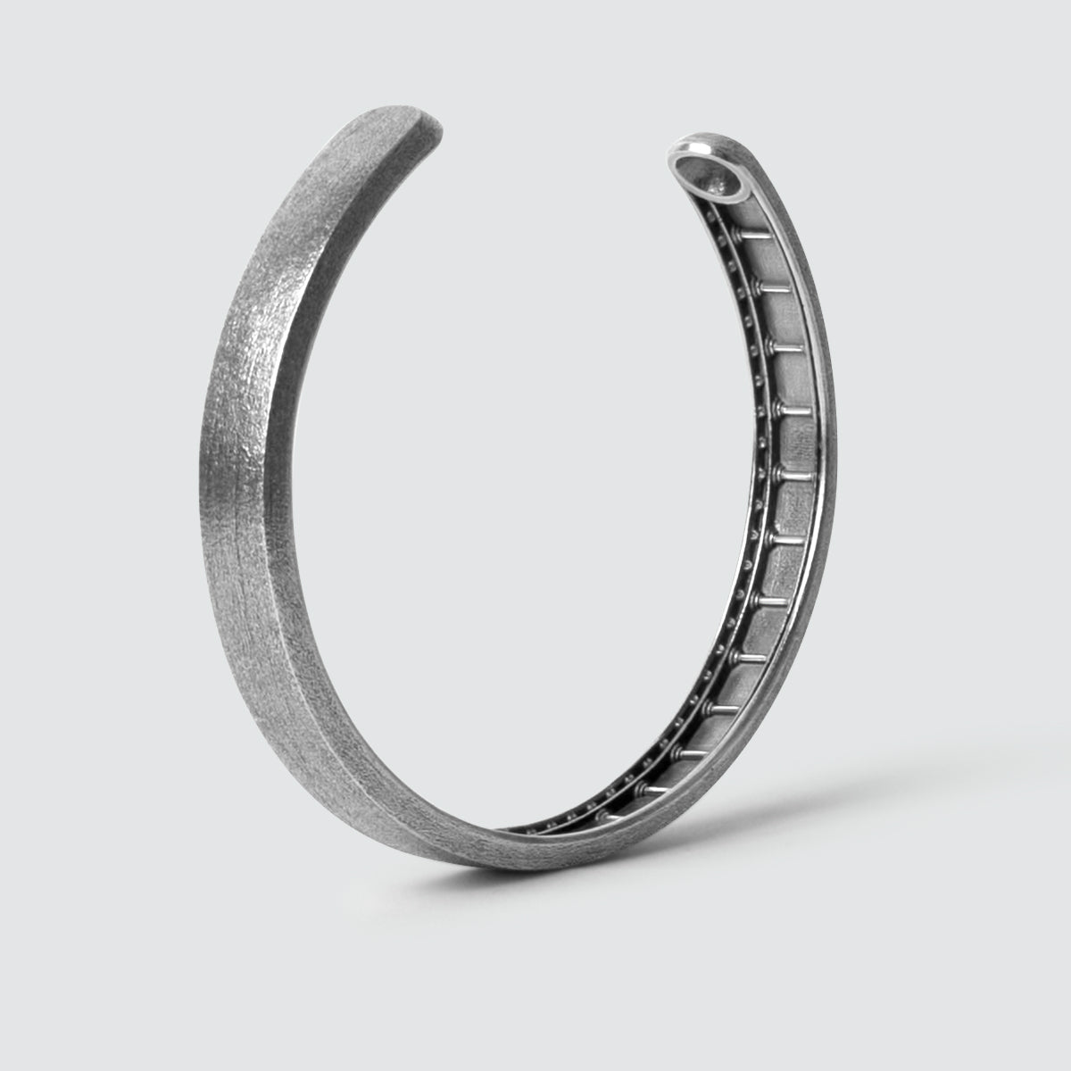 A Fudail - Rough Brushed Sterling Silver Bangle 8mm with a ring in the middle.