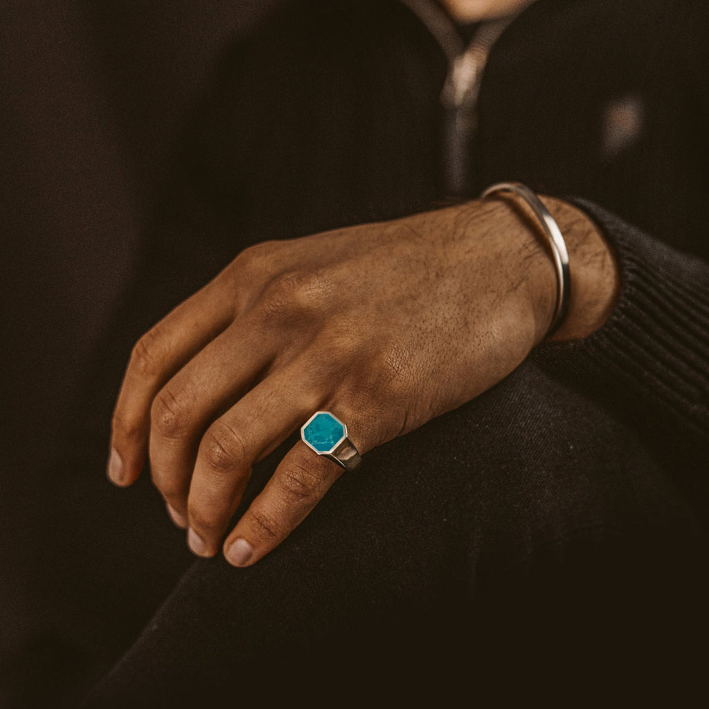 A man wearing the Nuri - Sterling Silver Blue Turquoise Signet Ring 13mm.