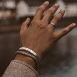 Une main d'homme avec un élégant bracelet Boulos - Plain Sterling Silver Jonc 8mm, ornant son poignet.