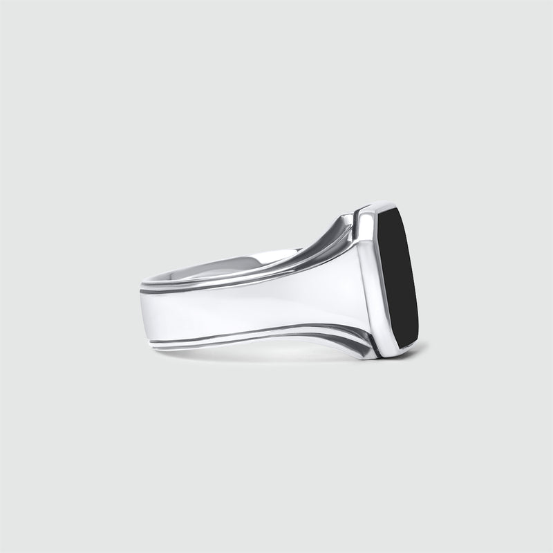 Zijaanzicht van de Ninetwofive Baki zegelring voor heren met zwarte onyx, met de details van de ringband op een witte achtergrond.